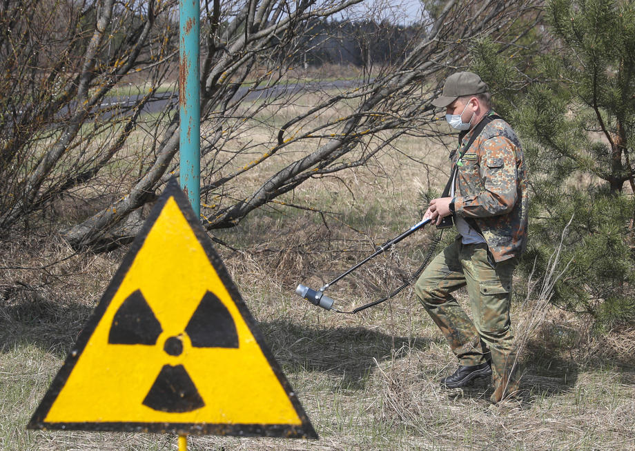 File photo. A dosimetrist walks past the radiation sign at the Chernobyl zone, Ukraine, 22 April 2021. Ukraine marked the 35th anniversary of Chernobyl tragedy on 26 April 2021. [EPA-EFE/SERGEY DOLZHENKO]